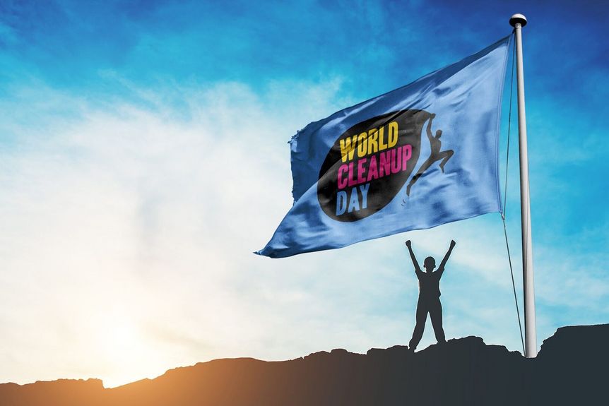Werbemotiv World Cleanup Day, Figur mit erhobenen Armen neben Fahne mit Schriftzug des Aktionstags